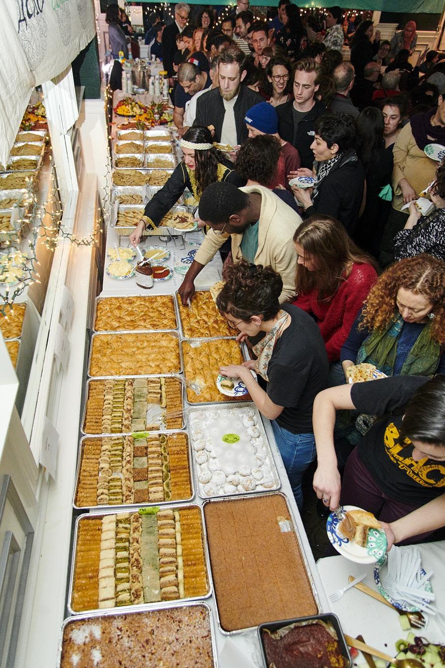 Celebrators gather around a table full of food