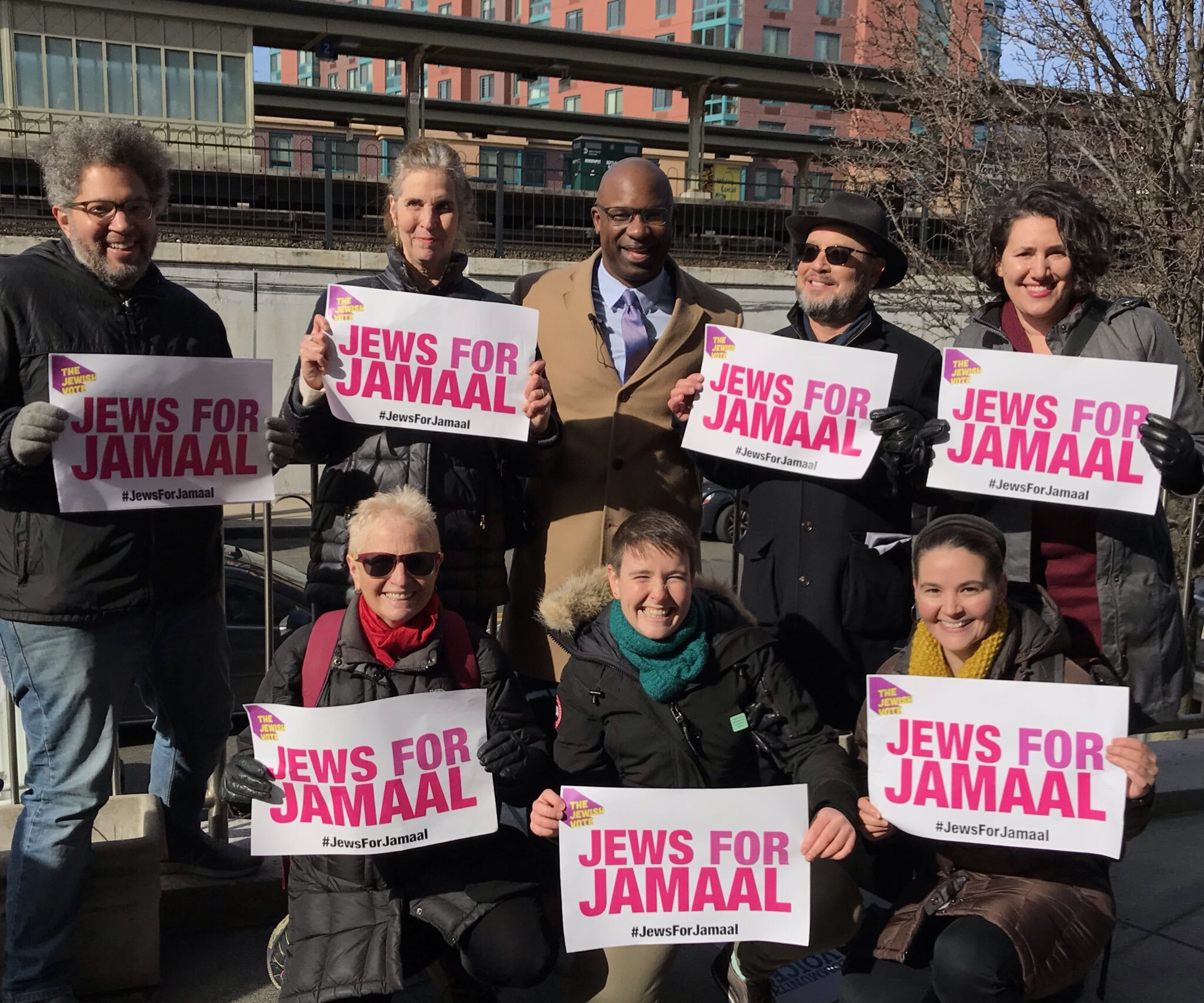 Photo of seven people holding Jews for Jamaal center, standing around Jamaal Bowman